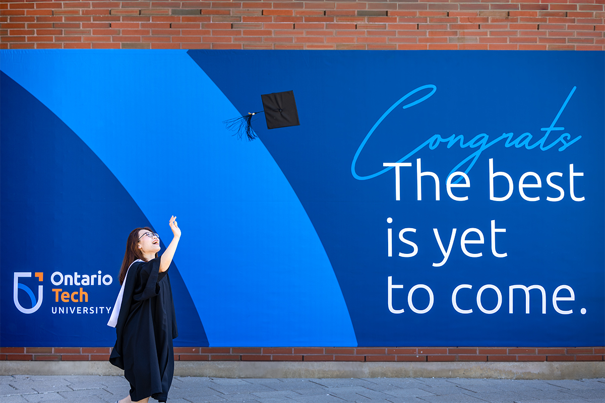 Graduate throwing cap in the air at Convocation