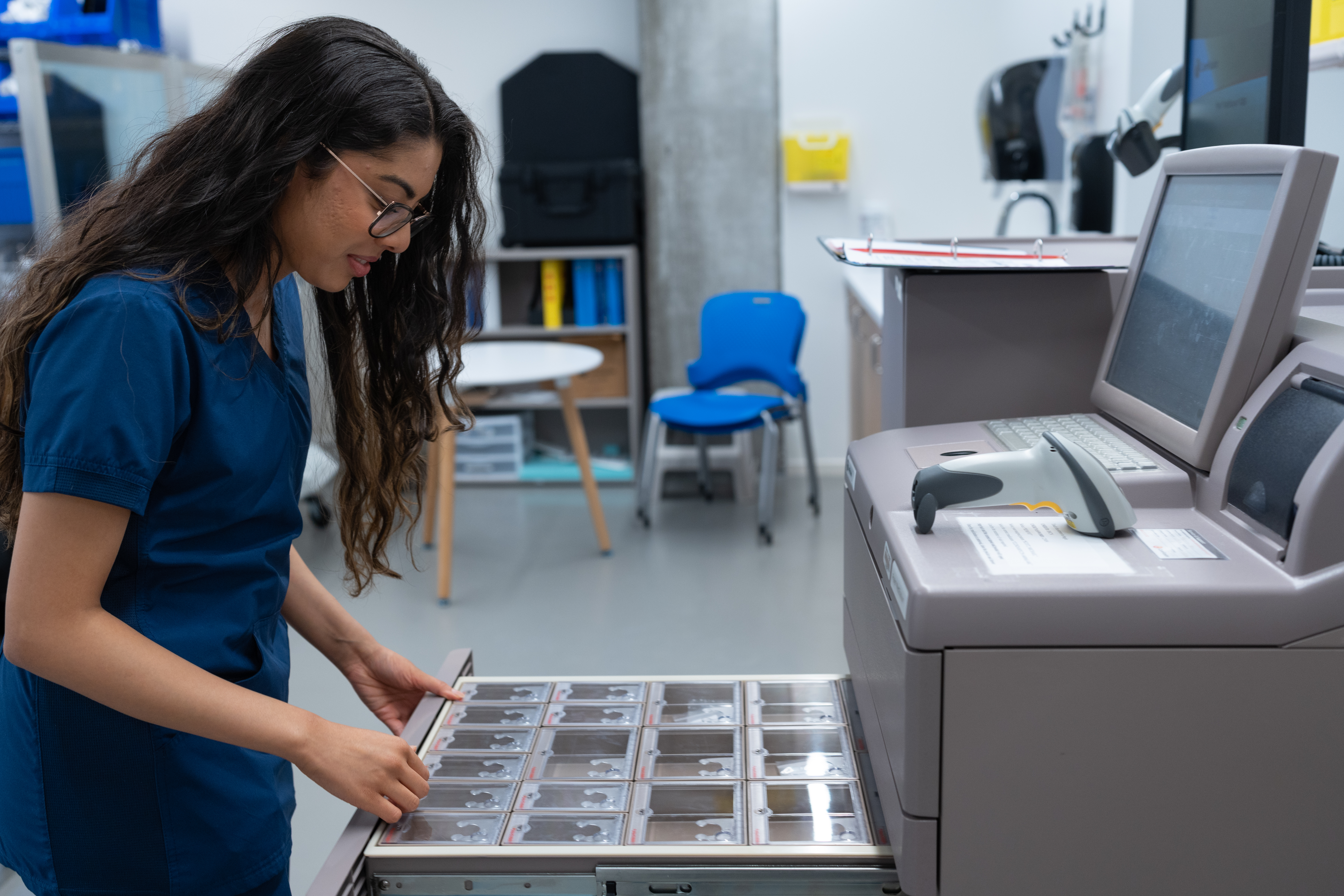 A nursing student standing looking at images from an x-ray scan